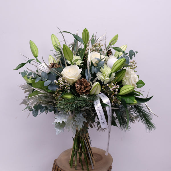 Christmas Lily Bouquet Stunning scent of white Lilies surrounding with Christmas foliage, white roses, wax flowers and green carnations. Please place your order by 1 pm for Same Day Flower Delivery in Dublin or Next Day Flowers Delivery Ireland and also Raheny Free Delivery