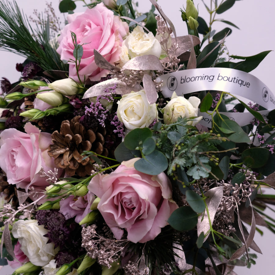 Christmas Pink Roses Flower Bouquet. Combination of pink roses and pink lisianthus with a festive touch of platinum foliage. We deliver flowers throughout Dublin and Ireland. Please place your order by 1 pm for Same Day Flower Delivery in Dublin or Next Day Flowers Delivery Ireland