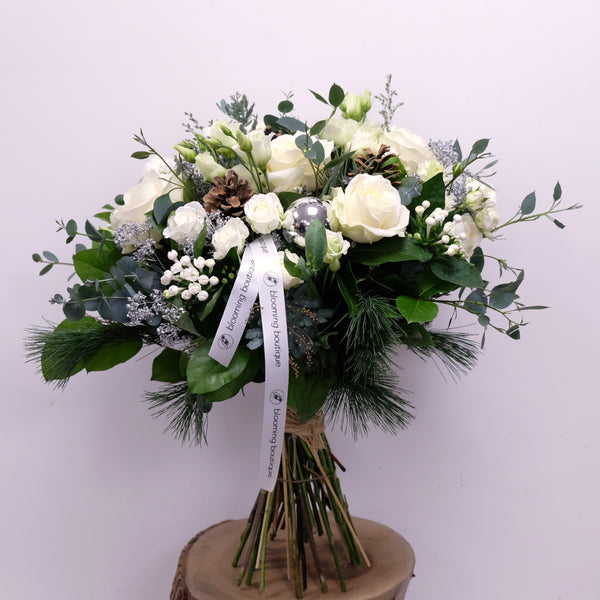 Combination of white blooms with silver foliage and pine cones. Christmas hand-tied bouquet "Christmas Symphony" includes Avalanche roses, white Lisianthus, spray roses, and Bouvardia. Please place your order by 1 pm for Same Day Flower Delivery in Dublin or Next Day Flowers Delivery Ireland and Raheny Free Delivery