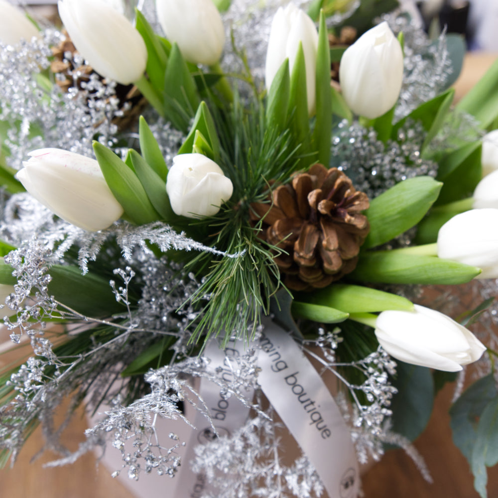Christmas Tulips Flower Bouquet. The pure beauty of white tulips with a festive touch of pine cones and silver foliage. We deliver flowers throughout Dublin and Ireland. Please place your order by 1 pm for Same Day Flower Delivery in Dublin or Next Day Flowers Delivery Ireland and also Raheny Free Delivery